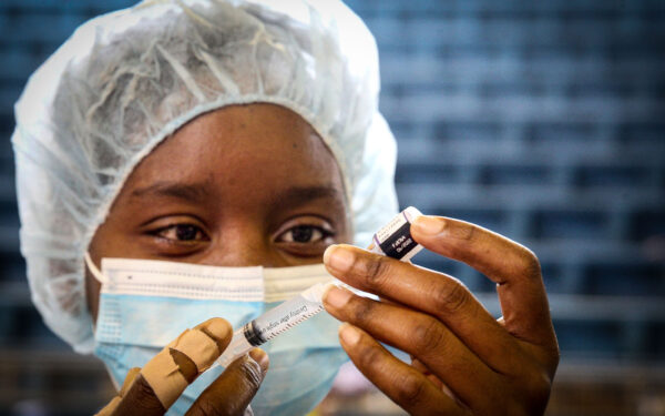 Uma profissional de saúde prepara uma dose da vacina contra a covid-19 para ser administrada a um jovem no Posto de Vacinação da Cidadela Desportiva, em Luanda, Angola, 17 de dezembro de 2021. Segundo a ministra da Saúde angolana, Sílvia Lutucuta, crianças e adolescentes entre os 12 e 17 anos vão começar a ser vacinados, salientando que há vacinas suficientes para a vacinação da população alvo, de 15,7 milhões. AMPE ROGÉRIO/LUSA