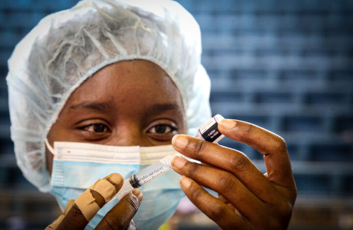 Uma profissional de saúde prepara uma dose da vacina contra a covid-19 para ser administrada a um jovem no Posto de Vacinação da Cidadela Desportiva, em Luanda, Angola, 17 de dezembro de 2021. Segundo a ministra da Saúde angolana, Sílvia Lutucuta, crianças e adolescentes entre os 12 e 17 anos vão começar a ser vacinados, salientando que há vacinas suficientes para a vacinação da população alvo, de 15,7 milhões. AMPE ROGÉRIO/LUSA