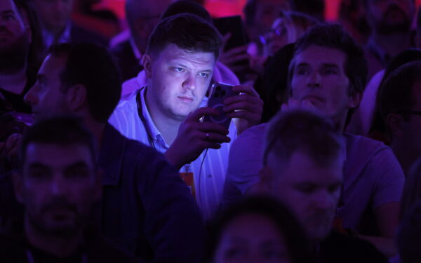 epa10973726 A member of the audience looks at a mobile device during the opening ceremony of the 2023 Web Summit in Lisbon, Portugal, 13 November 2023. The Web Summit is considered the largest event of startups and technological entrepreneurship in the world and takes place in Lisbon from 13 to 16 November.  EPA/ANTONIO PEDRO SANTOS