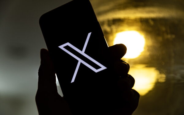 epa10772440 An illustration pictures shows a user holding a mobile phone displaying the 'X' logo, in Los Angeles, California, USA, 27 July 2023. Twitter announced on 23 July that it will rebrand to X.  EPA/ETIENNE LAURENT
