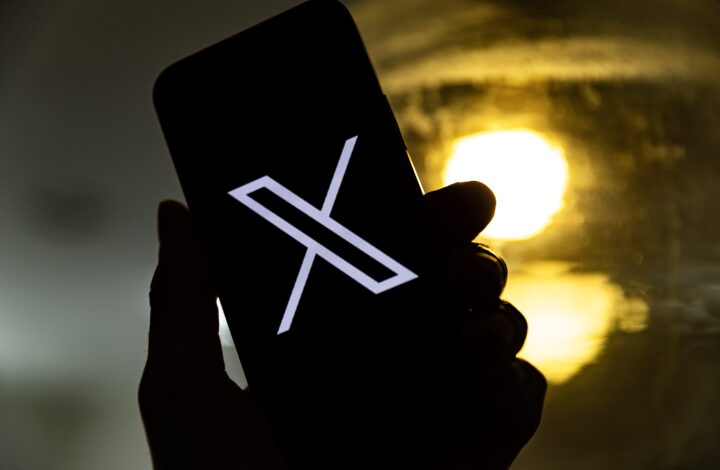 epa10772440 An illustration pictures shows a user holding a mobile phone displaying the 'X' logo, in Los Angeles, California, USA, 27 July 2023. Twitter announced on 23 July that it will rebrand to X.  EPA/ETIENNE LAURENT